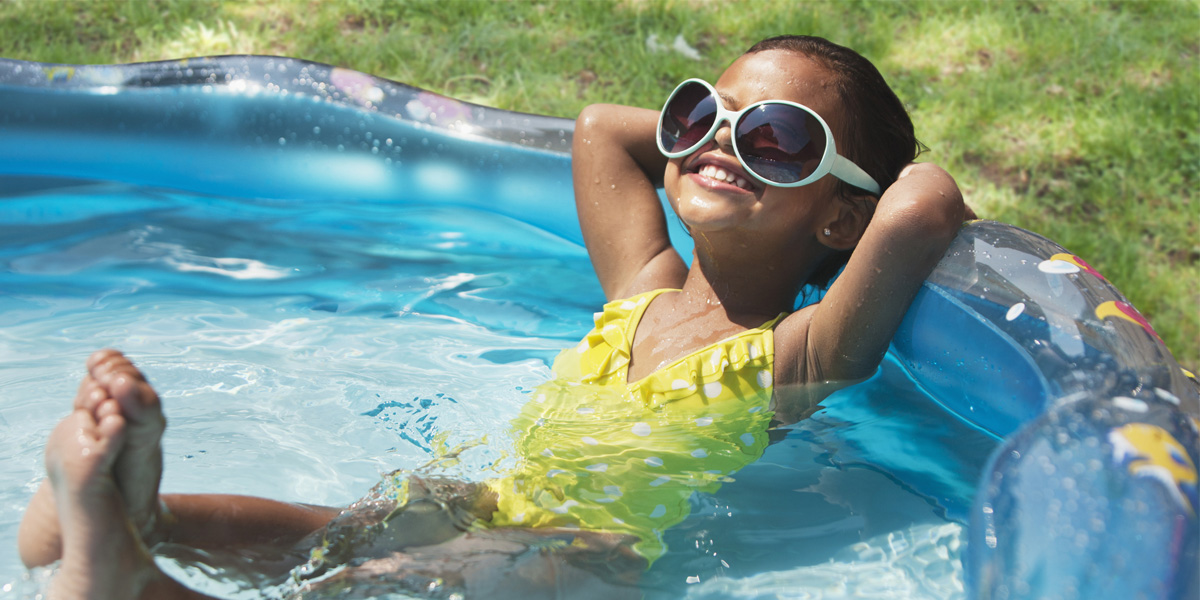 Little girl relaxing in inflatable pool